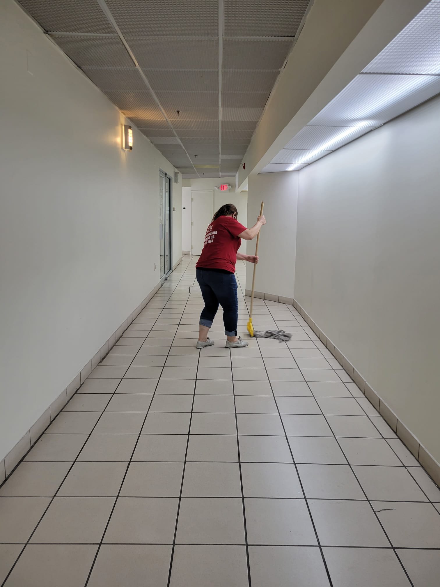G & General Master Contractor cleaning the floor of a shared building corridor